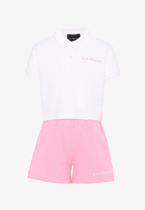 Polo bianca con scritta rosa "John Richmond" abbinata a pantaloncini rosa con vita elastica, entrambi capi casual per bambini.
