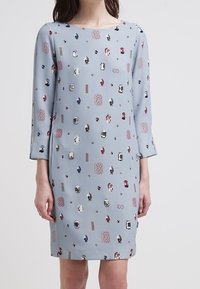 Jasnoniebieska sukienka z rękawami o długości trzech kwart, zdobiona różnorodnymi, przypominającymi klejnoty wzorami w odcieniach czerwieni, niebieskiego i srebra. Gładka faktura.