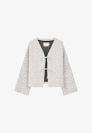 Biała krótka kurtka z rozproszonym czarnym wzorem kreskowym, długimi rękawami, dekoltem w serek oraz dwoma wiązanymi zapięciami z przodu.