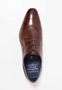 Zapato de vestir de cuero marrón con un acabado liso y texturizado, con cordones azules, puntera puntiaguda y plantilla de marca.