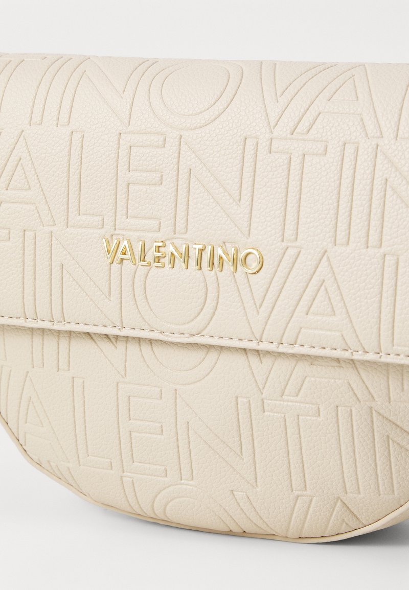 Borsa a tracolla in pelle beige con logo "VALENTINO" impresso, dotata di dettagli in hardware dorato e superficie testurizzata per una finitura opaca.