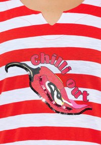 Pruhované tričko s červenými a bílými pruhy a výstřihem do V, se živou grafikou chilli papričky a třpytivým textem, který říká "chilli out."