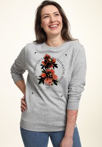 Grauer Pullover mit floralem Grafikdesign in Rot und Grün. Mit gerippten Bündchen und Saum sowie lässiger Passform. Sichtbare Jeans aus Denim.