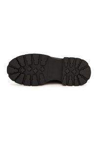 Suela de goma negra con profundos surcos y patrones cruzados para una mayor tracción. Diseño plano con una superficie robusta y texturizada para mayor durabilidad.