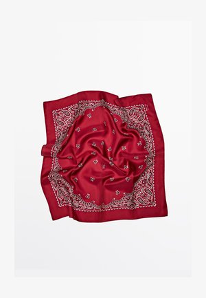 Czerwona jedwabna bandana z białym wzorem paisley i misternym wzorem na obwodzie, o gładkiej, błyszczącej fakturze i złożona.