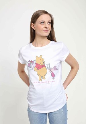 T-shirt en coton blanc avec un graphique cartoon coloré d'un ours et d'un petit cochon tenant des fleurs, avec le texte "nous serons amis pour toujours".