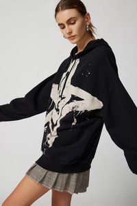 Black hoodie with a large white graphic design, featuring a drawstring hood and long sleeves, paired with a plaid pleated skirt.