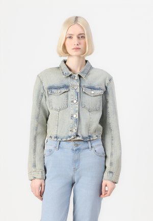 Giacca di denim azzurro chiaro con una vestibilità corta, bottoni a pressione, due tasche frontali e una texture sbiadita, abbinata a jeans azzurro chiaro coordinati.