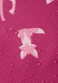 Ροζ ύφασμα με λείο υφή, που διαθέτει floral σχέδιο σε λευκό, επικαλυμμένο με σταγόνες νερού για γυαλιστερό αποτέλεσμα.