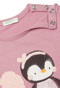 Rosa T-Shirt mit einem Pinguin-Design und flauschigen Akzenten, rundem Halsausschnitt mit Druckknöpfen und aus weicher Baumwolle gefertigt.