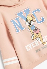 Sudadera rosa de tela suave, que presenta un gráfico de un personaje de dibujos animados y un texto en negrita "NYC". Incluye franjas blancas en las mangas.