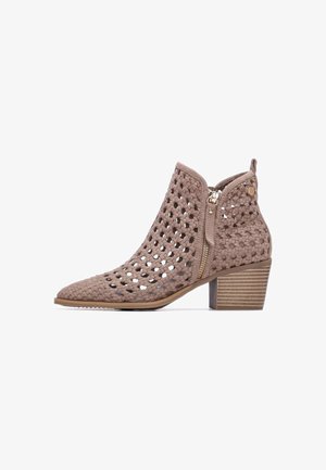 Bota de tobillo tejida en color topo con diseño de celosía abierta, cremallera lateral, tacón bajo de bloque apilado y punta redonda sobre fondo blanco.