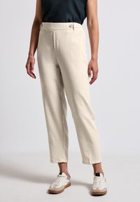Beige trousers with a textured fabric, straight cut, and high waist, features two side pockets and accent buttons at the waistband.