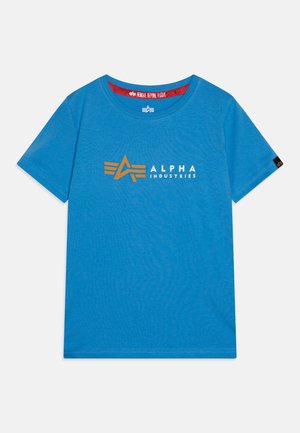 Blaues Baumwoll-T-Shirt mit einem orange-weißen "ALPHA INDUSTRIES" Logo in modernem Design. Rundhalsausschnitt mit einem roten Etikett "REMOVE BEFORE FLIGHT".