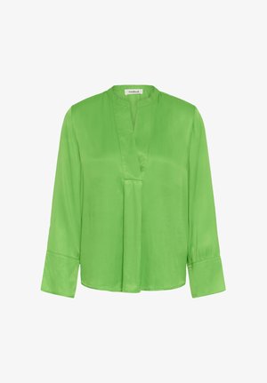 Zöld hosszú ujjú blúz álló gallérral, V-alakú nyakkivágással és széles mandzsettákkal, sima, fényes anyagból készült.