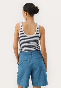 Blue denim shorts with a cuffed hem and side pockets paired with a navy and white striped tank top featuring wide straps and a scoop back.