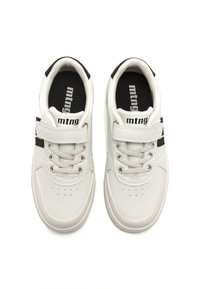 Zapatillas blancas con textura de cuero lisa, con acentos negros, una correa de velcro y cordones redondos. Incluyen detalles perforados en la punta.