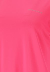 Ljusrosa idrottströja gjord av ett slätt, lätt tyg, med en diskret "ENDURANCE"-logotyp i silver. Enkel design med korta ärmar.