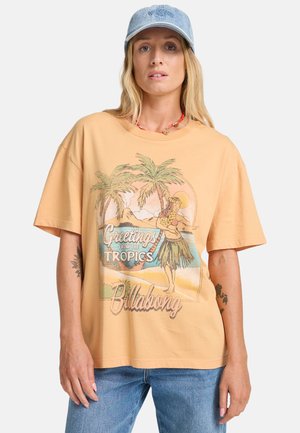 Camiseta de manga corta de color melocotón con un gráfico tropical que presenta palmeras y una bailarina de hula, hecha de algodón y con un corte holgado.