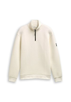 Pullover bianco con zip realizzato in tessuto testurizzato, dotato di colletto alto e zipper nera. I polsini e l'orlo a costine accentuano il design.