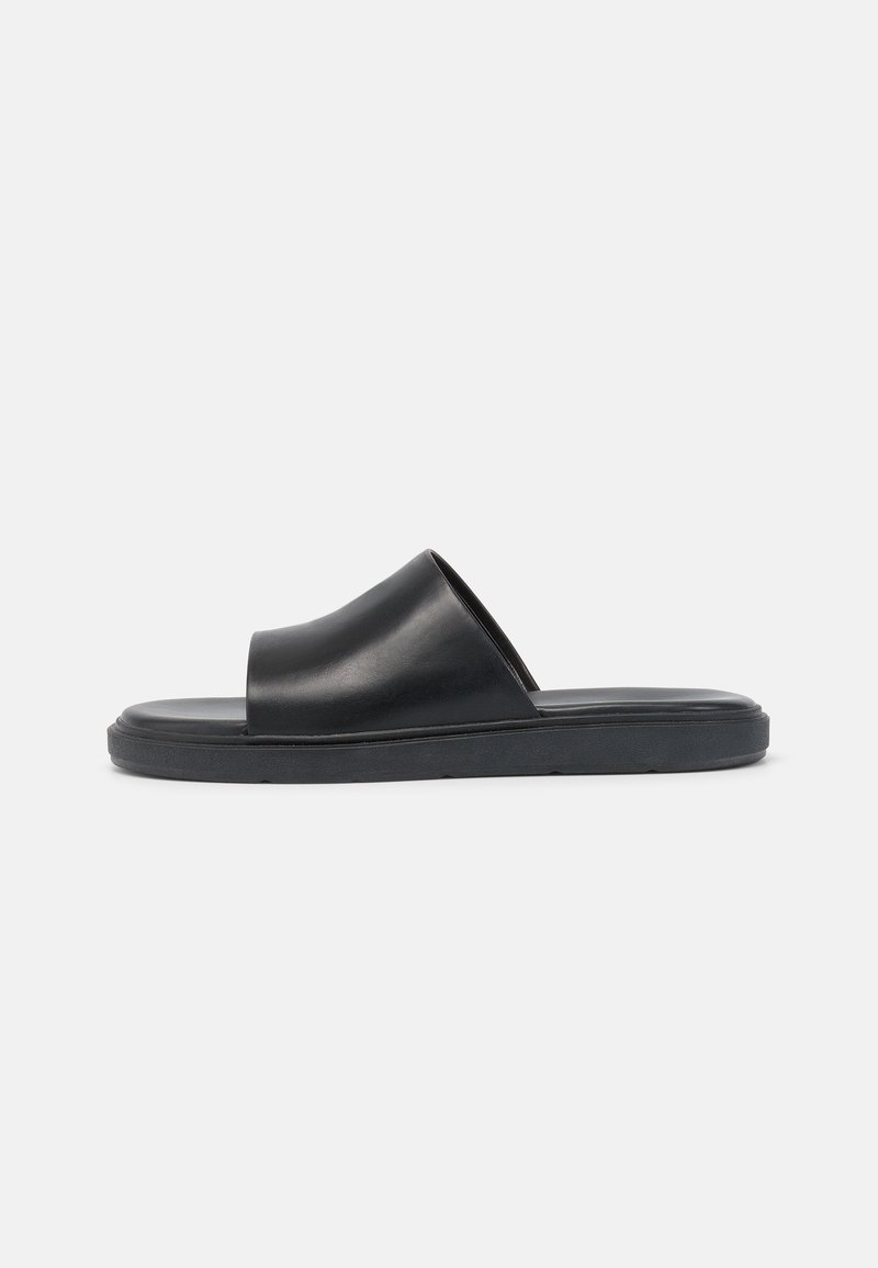 Crne klizne sandale s glatkom kožnom gornjom doradom, otvorenim prstima i ravnim gumenenim đonom. Minimalistički dizajn s elegantnom siluetom.