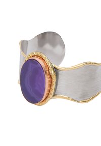 Hopeaketja hopeasta, jossa on aaltoileva muotoilu, keskellä ovaali violetista akaatista tehty kivi, joka on kehystetty kuparilla ja kultakoristeilla.