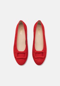 Ballerines en nubuck rouge avec un bout rond et un accent de nœud décoratif à l'avant. Doublure intérieure douce et esthétique minimaliste.