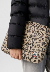 Funda de portátil acolchada con estampado de leopardo en beige, marrón y negro. Presenta un parche de logo circular y una superficie texturizada.