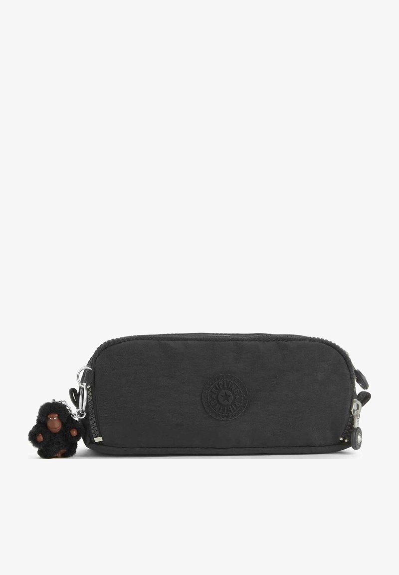 Trousse de maquillage en tissu noir avec fermeture éclair, logo circulaire et un petit porte-clés en forme de singe en peluche attaché sur un côté.