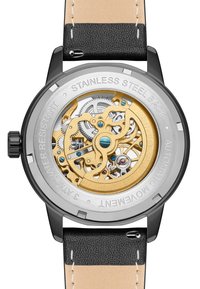Automatisk klokke med bakside i rustfritt stål, gulltannhjul, svart lærrem og beige detaljer. Har intrikate mekaniske detaljer.