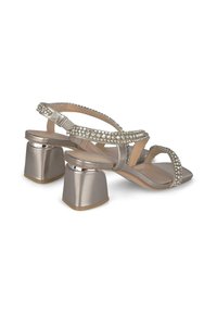 Sandalias de tacón plateadas metálicas con puntera cuadrada, adornadas con strass, que cuentan con dos correas cruzadas y un tacón de bloque resistente.