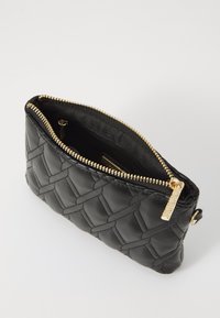 Black leather clutch bag with quilted pattern, featuring a golden zipper and pull tab, and a smooth interior lining. Compact rectangular shape.