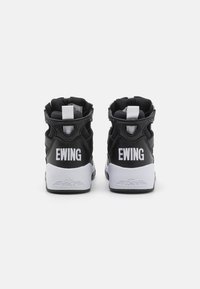 Baskets montantes noires avec des accents blancs, comportant le texte "EWING" au dos, en cuir lisse et avec une semelle en caoutchouc texturé.