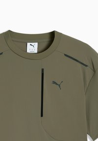 T-shirt de sport Puma vert olive avec col rond, bande verticale noire et logo Puma sur la poitrine, montrant le devant et l'épaule droite.