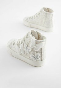 Vita högskurna sneakers med en texturerad, glittrig ovandel med broderade fjärilar och pärlprydnader. Gummisula med snörningsdesign.