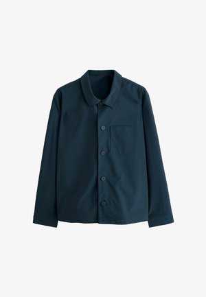 Tamsiai mėlynos spalvos marškiniai su mygtukais, pagaminti iš lygaus audinio. Juose yra klasikinis apykaklė, priekinė kišenė ir šeši mygtukai priekyje.