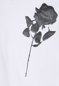 Black and gray graphic of a single rose with thorns and leaves on a white background.
