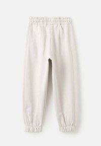 Pantalons de survêtement gris clair avec taille élastique et poignets froncés, texture lisse et coutures latérales pour un ajustement décontracté. Pas de motifs ni d'accents visibles.