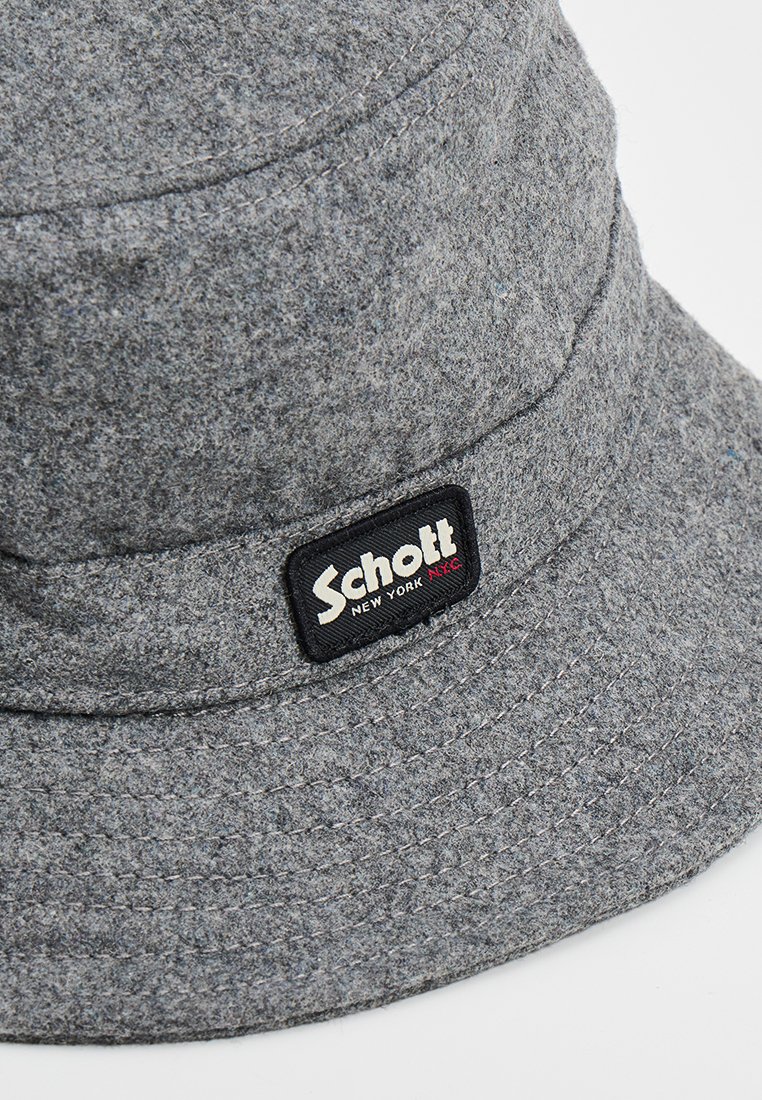 Cappello a secchi grigio in feltro con etichetta nera con "Schott New York" in testo bianco, strutturato, con una ampia visiera e tessuto testurizzato.