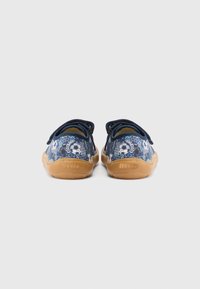 Tmavomodré plátené topánky s kvetinovým vzorom, elastickými šnúrkami a svetlohnedou gumovou podrážkou. Na päte je logo "froddo".