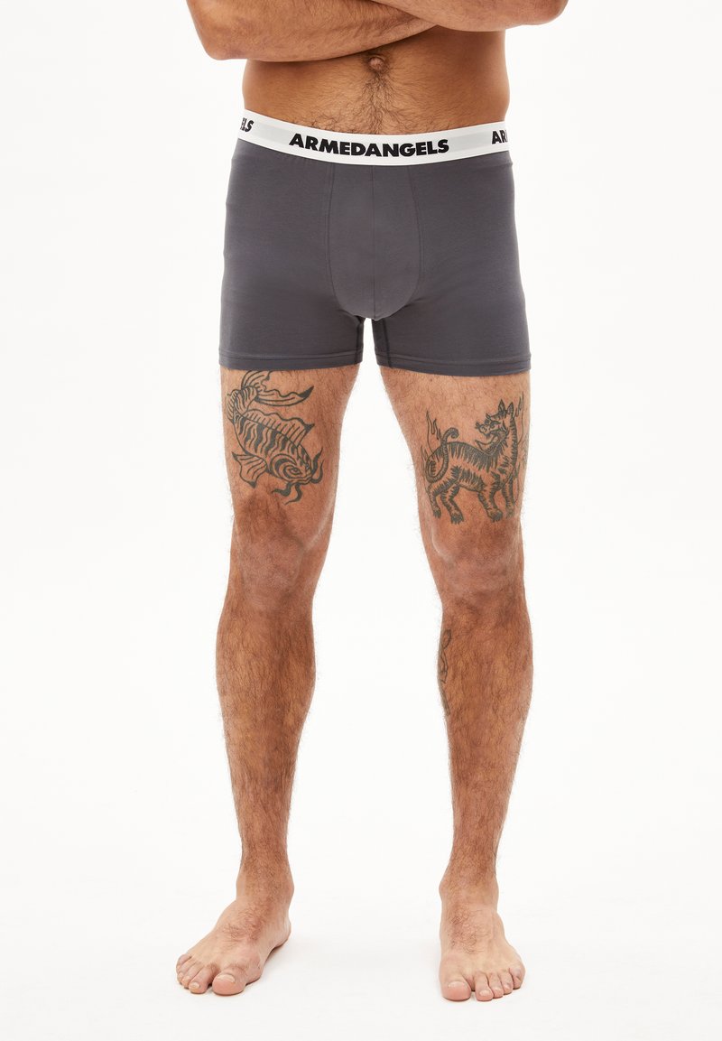 Dunkelgraue Herrenboxershorts mit einem weißen Markenbund. Hergestellt aus weichem Stoff, mit einer engen Passform und einer glatten Textur.