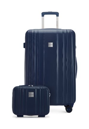 Maleta rígida texturizada de color azul marino con asa telescópica y pequeño estuche de viaje a juego, ambos con placas de marca plateadas.