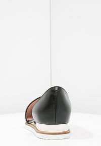 Czarny skórzany but z okrągłym noskiem, cienką białą podeszwą i eleganckim designem. Posiada gładką teksturę i minimalistyczne akcenty.