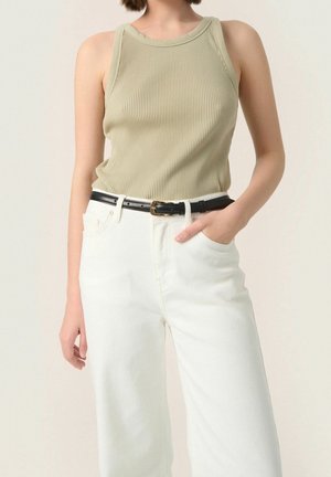 Ribbet, lyse olivenfarvet tanktop med brede stropper, parret med højlivede, hvide denimbukser og et sort bælte med en gylden spænde.