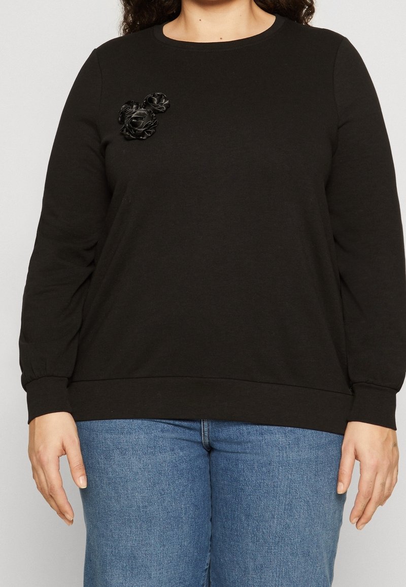 Black sweatshirt made of soft material, featuring a round neckline and long sleeves. Three black fabric flowers adorn the chest area.