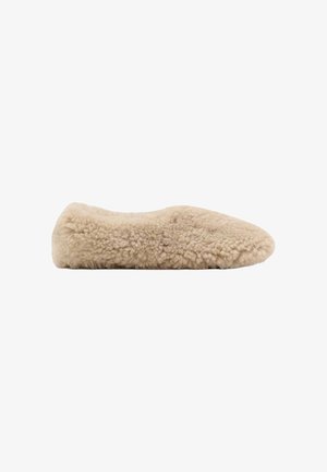 Beige fuzzy slip-on sko med rund tå og lav profil, helt dækket af blødt, krøllet tekstil.