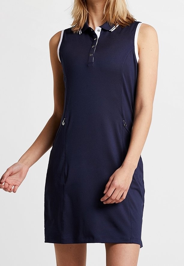 Robe polo sans manches bleu marine avec bordure blanche sur le col et les emmanchures portée par une personne debout devant un fond uni.