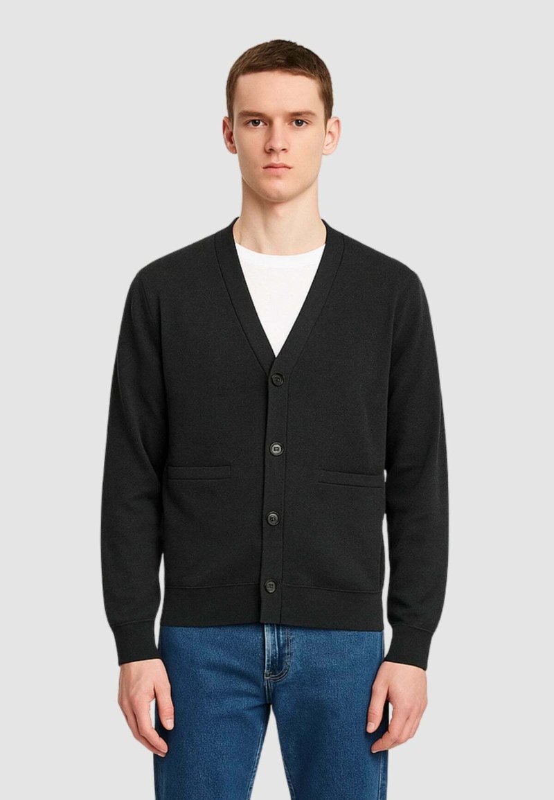Cardigan nero con design a V, sei bottoni e due tasche frontali. Tessuto morbido e maniche lunghe, abbinato a jeans blu.