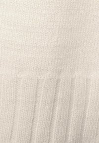 Vit stickad tyg med en strukturerad, ribbad mönstring och en mjuk, ludet yta, lämplig för plagg eller accessoarer.