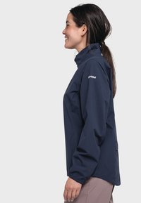 Marineblau wasserfeste Jacke mit hohem Kragen, elastischen Bündchen und einer seitlichen Reißverschlusstasche. Leichter Stoff mit glatter Textur und minimalem Branding.